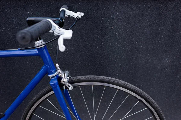 Una bicicletta blu vicino al muro grigio sulla strada — Foto stock