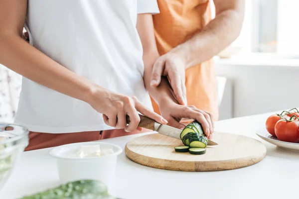 Recortado disparo de marido y mujer preparando ensalada juntos - foto de stock