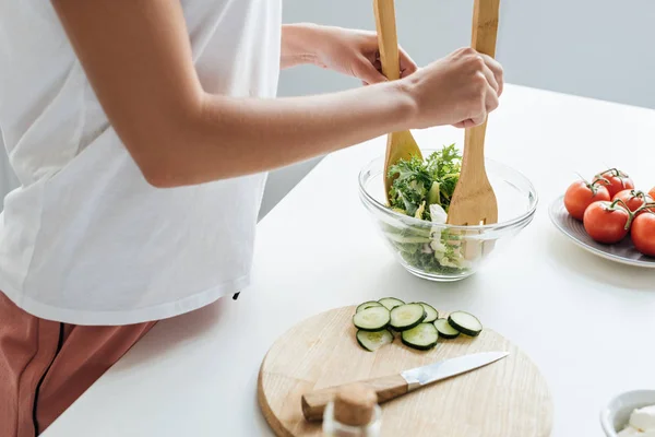 Tiro recortado de la mujer que prepara deliciosa ensalada saludable - foto de stock