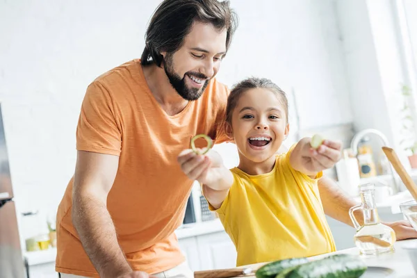 Отец и дочь веселятся на кухне во время приготовления пищи — стоковое фото