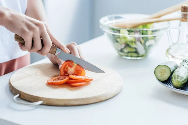 Foto recortada de mujer cortando tomate para ensalada - foto de stock