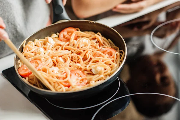 Cropped shot of woman preparing delicious pasta on frying pan — Stock Photo