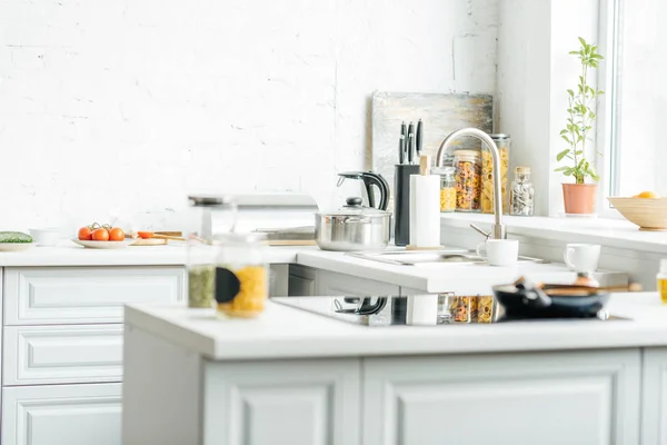 Інтер'єр порожньої сучасної білої кухні з різними предметами на столі — стокове фото