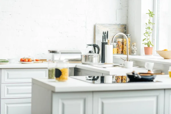 Interior de la cocina blanca moderna vacía con varios objetos en la mesa - foto de stock