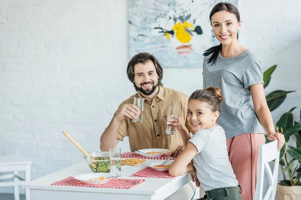 Beautiful young family eating breakfast together — Stock Photo