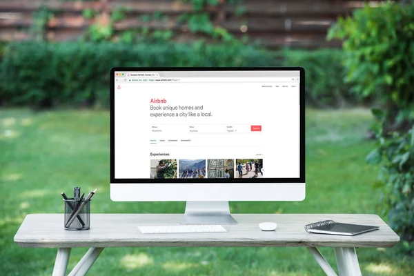 Enfoque selectivo de la computadora con airbnb sitio web en la mesa al aire libre - foto de stock