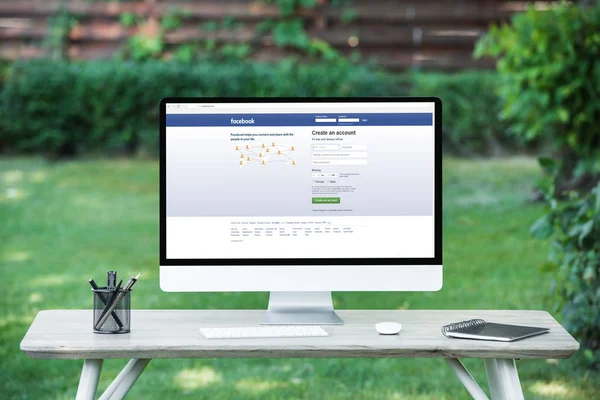 Selective focus of computer with facebook website at table outdoors — Stock Photo