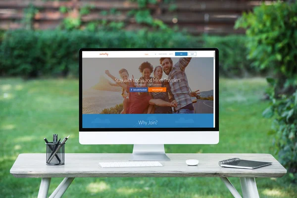 Selective focus of computer with couchsurfing website at table outdoors — Stock Photo