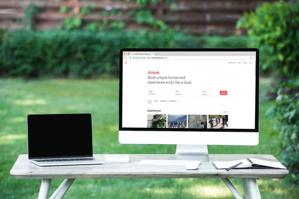 Selective focus of laptop with blank screen computer with airbnb website at table outdoors — Stock Photo