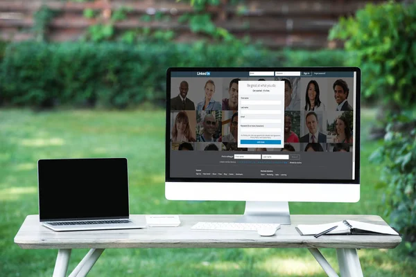 Selective focus of laptop with blank screen computer with linkedin website at table outdoors — Stock Photo
