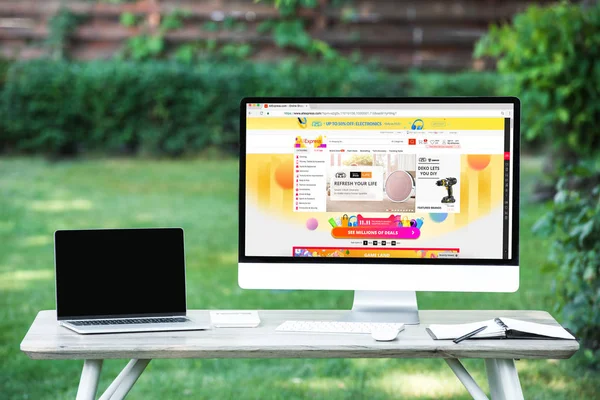 Selective focus of laptop with blank screen computer with aliexpress website at table outdoors — Stock Photo