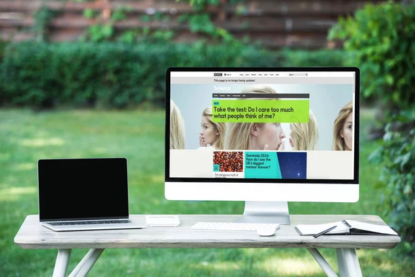 Selective focus of laptop with blank screen computer with bbc science website at table outdoors — Stock Photo