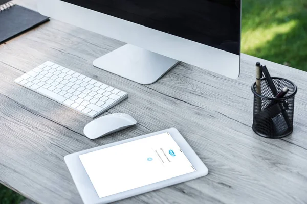 Foyer sélectif de la tablette numérique avec skype site Web et ordinateur avec écran blanc à la table à l'extérieur — Photo de stock