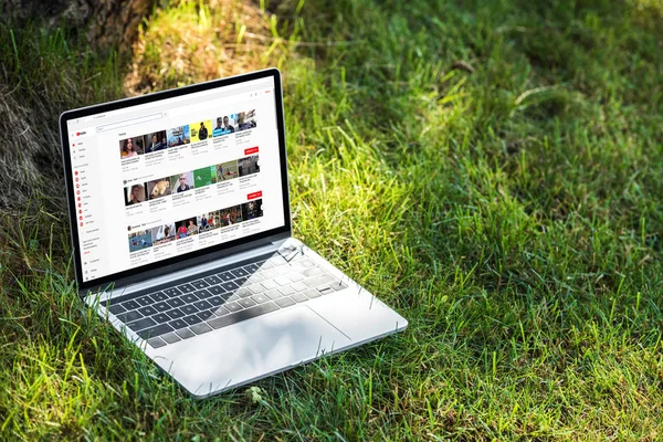 Close up view of laptop with youtube website on grass outdoors — Stock Photo