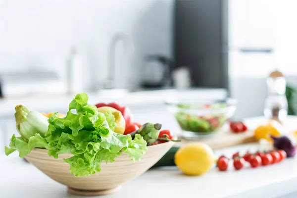 Vista de cerca del tazón con verduras frescas y saludables en la mesa de la cocina - foto de stock