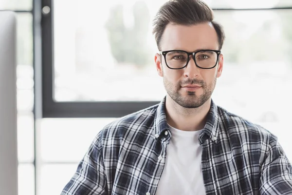 Portrait of handsome young man in eyeglasses looking at camera — Stock Photo