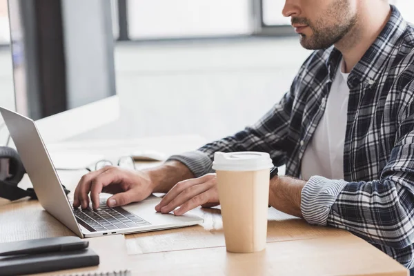 Erschossener junger Mann mit Laptop am Arbeitsplatz — Stockfoto