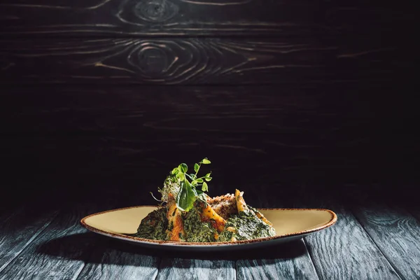 Panikesh avec noix de cajou et épinards sur assiette sur table en bois — Photo de stock