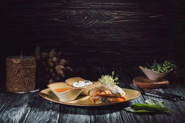Nahrungsmittelkomposition aus Kerze und Samosas in Phyllo-Teig gefüllt mit Spinat und Paneer dekoriert mit gekeimten Samen von Luzerne und Sonnenblume auf Teller mit Soßen — Stockfoto