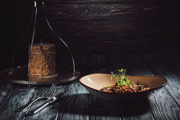 Composition alimentaire de bougie, fourchette avec couteau, soba au tofu et légumes décorés de graines germées de tournesol — Photo de stock