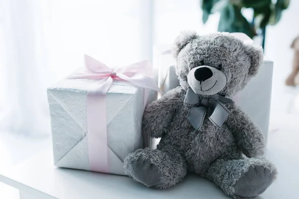 Selective focus of teddy bear with gift boxes on table — Stock Photo