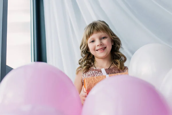 Happy birthday child holding gift box and looking at camera — Stock Photo