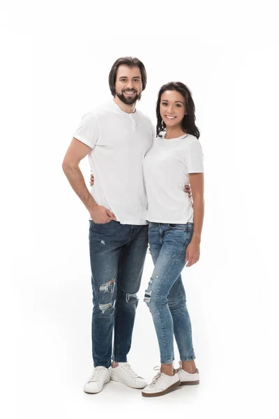 Улыбающаяся пара обнимается и смотрит на камеру, изолированную на белом — стоковое фото