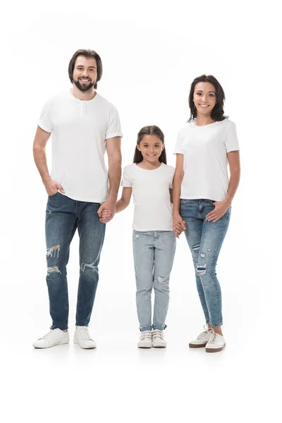 Familia sonriente en camisas blancas cogidas de la mano y mirando a la cámara aislada en blanco - foto de stock