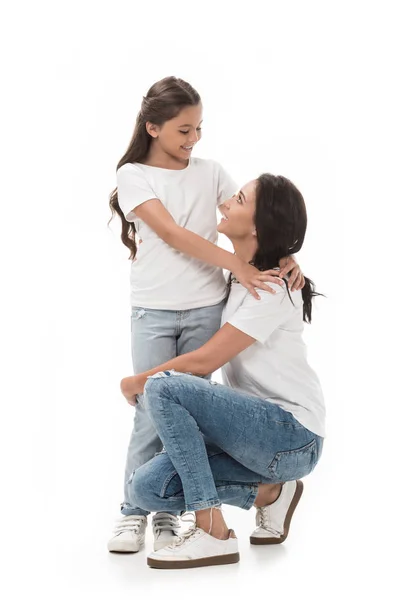 Glückliche Mutter und Tochter sehen einander isoliert auf weißem Grund an — Stockfoto