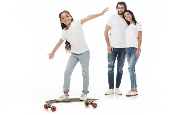 Pais sorridentes olhando para a filha patinando no skate isolado no branco — Fotografia de Stock