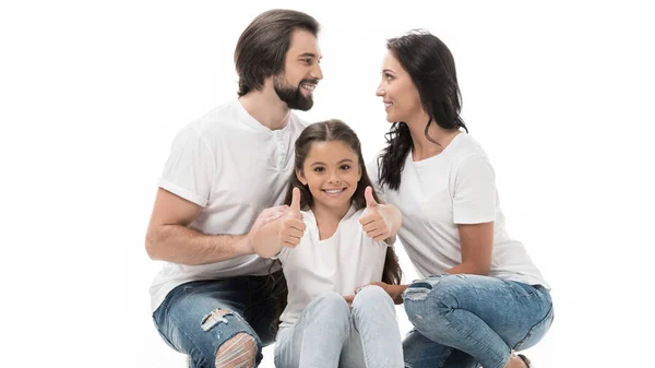 Retrato de niño sonriente mostrando los pulgares hacia arriba con los padres detrás aislados en blanco - foto de stock