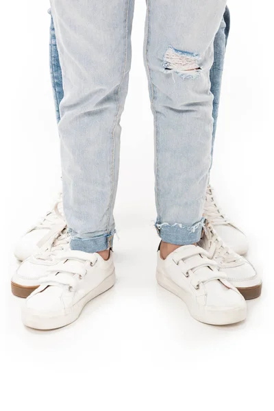 Vista parziale della famiglia in jeans e calzature bianche isolate su bianco — Foto stock