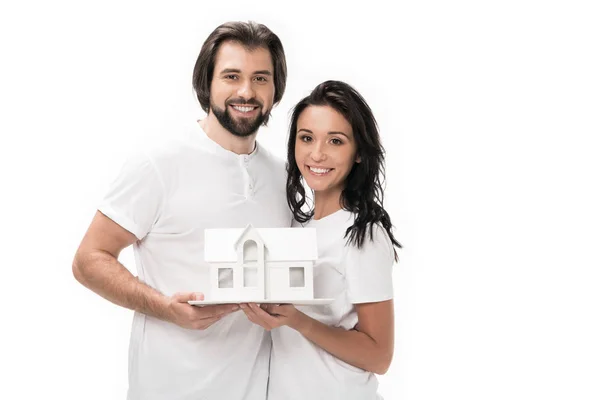 Portrait de couple souriant avec modèle de maison isolé sur blanc — Photo de stock