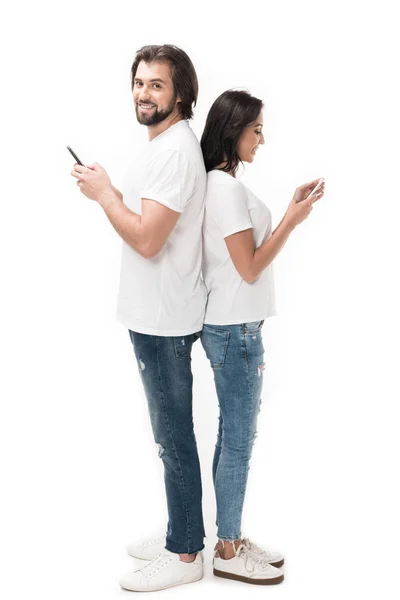 Vista lateral de pareja con smartphones aislados en blanco - foto de stock