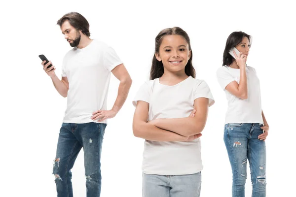 Enfoque selectivo del niño sonriente y los padres utilizando teléfonos inteligentes aislados en blanco - foto de stock