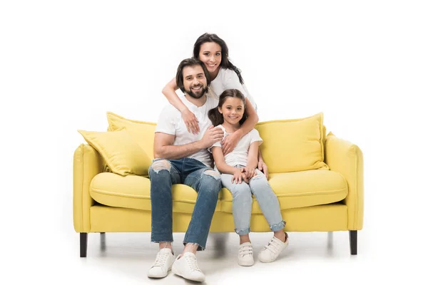 Усміхнена жінка обіймає сім'ю на жовтому дивані ізольовано на білому — стокове фото
