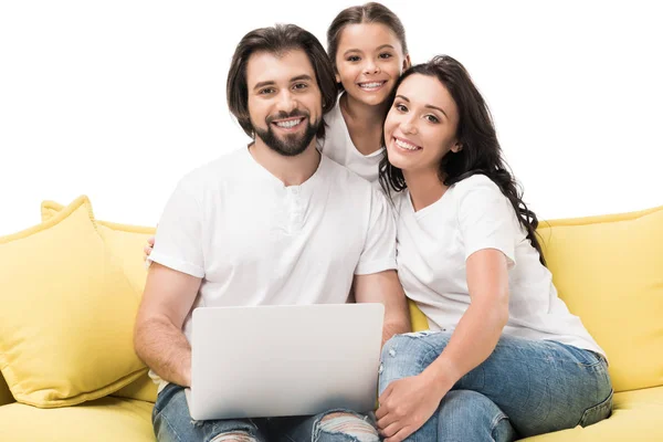 Porträt einer lächelnden Familie mit Laptop auf gelbem Sofa isoliert auf weißem Hintergrund — Stockfoto