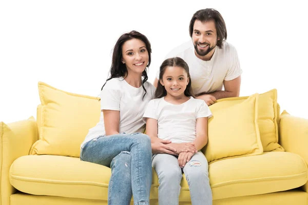 Porträt einer fröhlichen Familie in weißen Hemden auf gelbem Sofa isoliert auf weißem Sofa — Stockfoto
