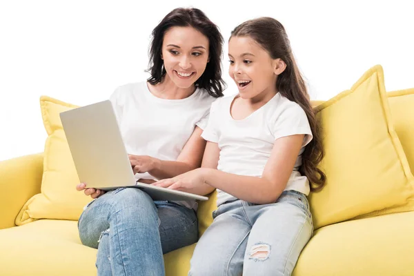 Retrato de la madre y la hija feliz usando el ordenador portátil juntos en el sofá aislado en blanco - foto de stock