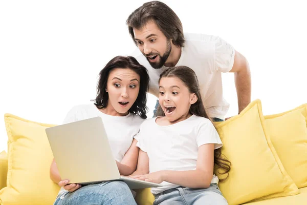 Famille émotionnelle utilisant ordinateur portable ensemble sur canapé jaune isolé sur blanc — Photo de stock