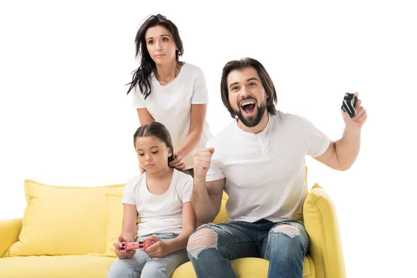 Feliz hombre y familia molesta jugando videojuegos en sofá amarillo aislado en blanco - foto de stock