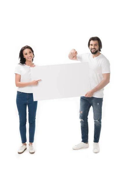 Smiling couple pointing at blank banner isolated on white — Stock Photo