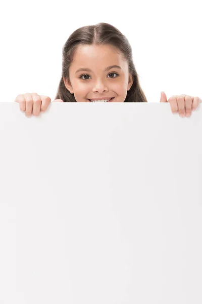 Niño sonriente con pancarta en blanco en las manos mirando a la cámara aislada en blanco - foto de stock