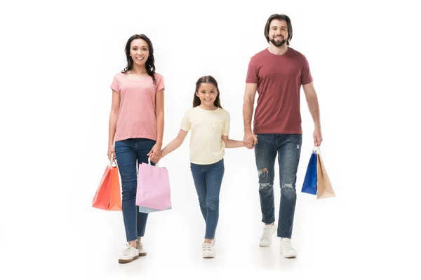 Smiling family with shopping bags holding hands isolated on white — Stock Photo
