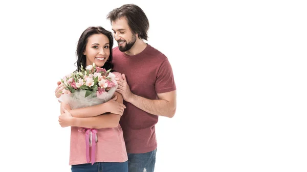 Retrato de mujer sonriente con ramo de flores y marido aislado en blanco - foto de stock