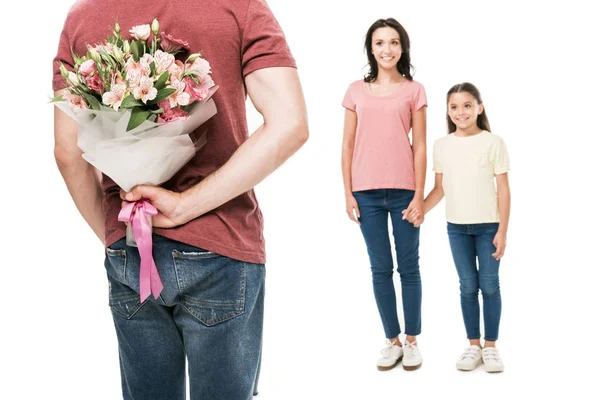 Partial view of man with bouquet of flowers behind back and smiling family isolated on white — Stock Photo