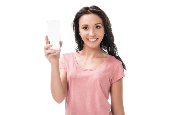 Porträt einer lächelnden Frau mit einem Glas Wasser in der Hand, die isoliert auf weiß in die Kamera blickt — Stockfoto