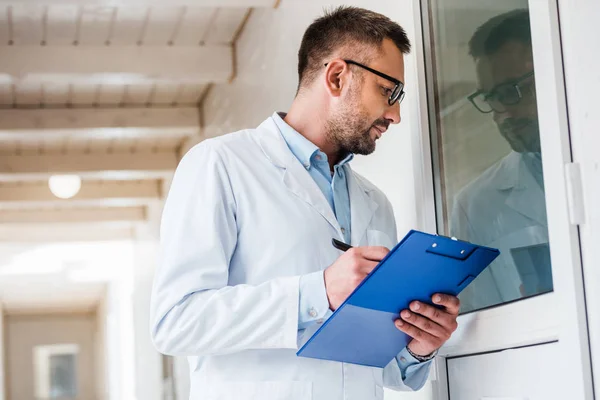 Vista laterale del veterinario con gli appunti sale di controllo presso la clinica veterinaria — Foto stock