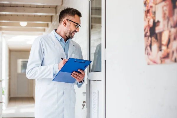 Handsome veterinarian with clipboard checking rooms at veterinary clinic — Stock Photo