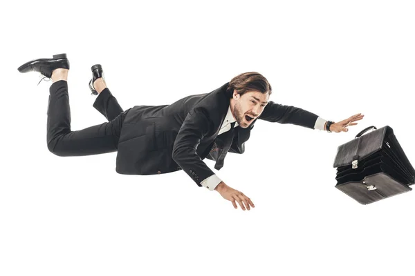 Asustado joven empresario cayendo con maletín aislado en blanco - foto de stock